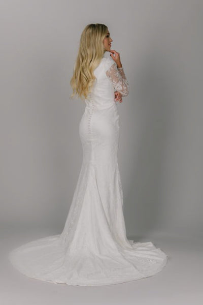 This is the back of the lacey modest wedding gown with buttons down the back ad a semi long train.