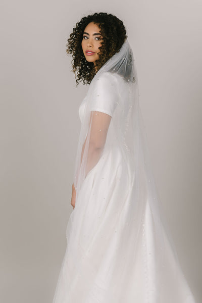 This is a front shot of a long veil with pearl details.