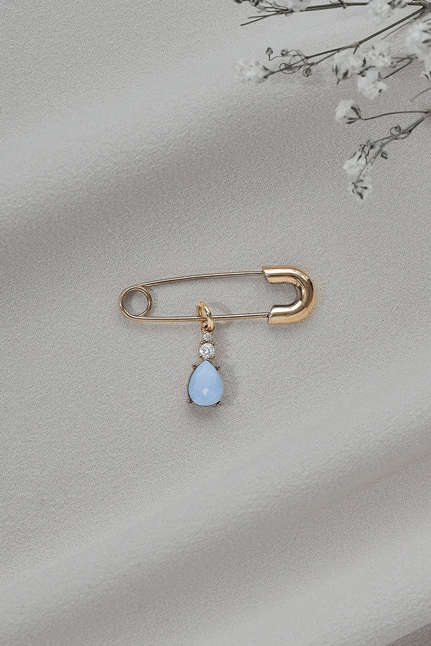 A basic shot of a "something blue" pin featuring a baby blue teardrop gem.