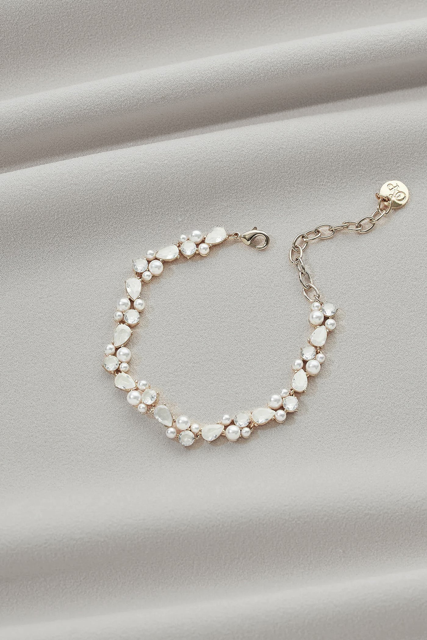 A gold bracelet with teardrop gems and little pearl details.