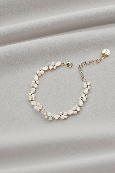 A gold bracelet with teardrop gems and little pearl details.