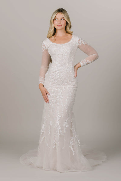 This is a very intricate modest wedding gown with lacey details and sheer long sleeves.