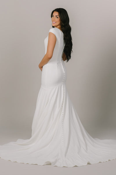 Our Averie dress is a stunning modest wedding dress with a mermaid silhouette and cap sleeves. This dress is perfect for the bride aiming for a classy, regal wedding!