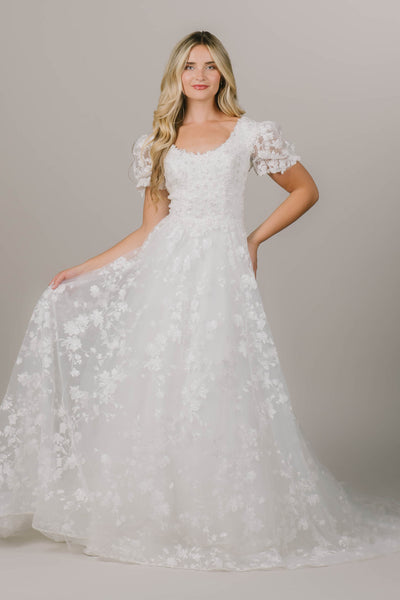 This is an intricate modest wedding gown with floral lace and a fun puff sleeve.
