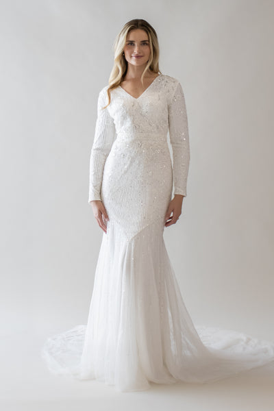 This is a modest wedding dress with a beaded bodice, mermaid silhouette, and a v-neckline. 