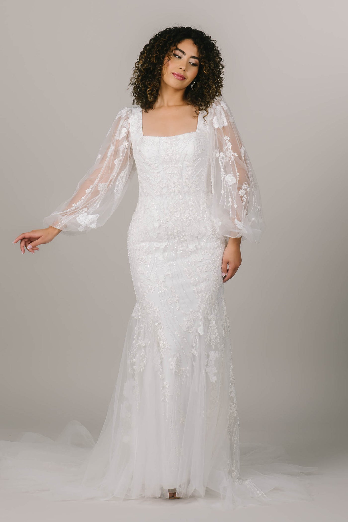 This is an alternate shot of a modest wedding dress with lace balloon sleeves and a square neckline.