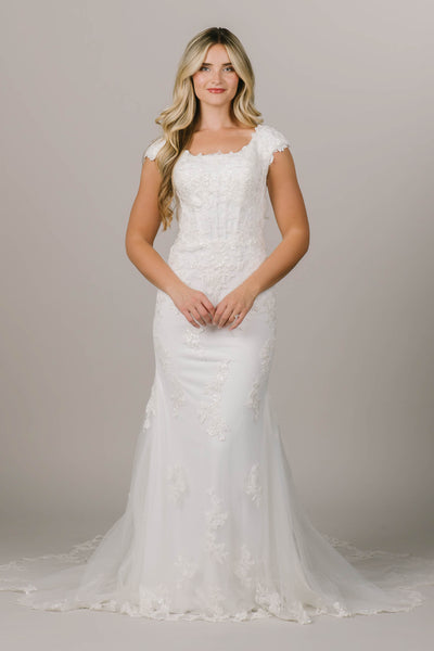This is a white modest wedding dress with a lace bodice and boning on it.
