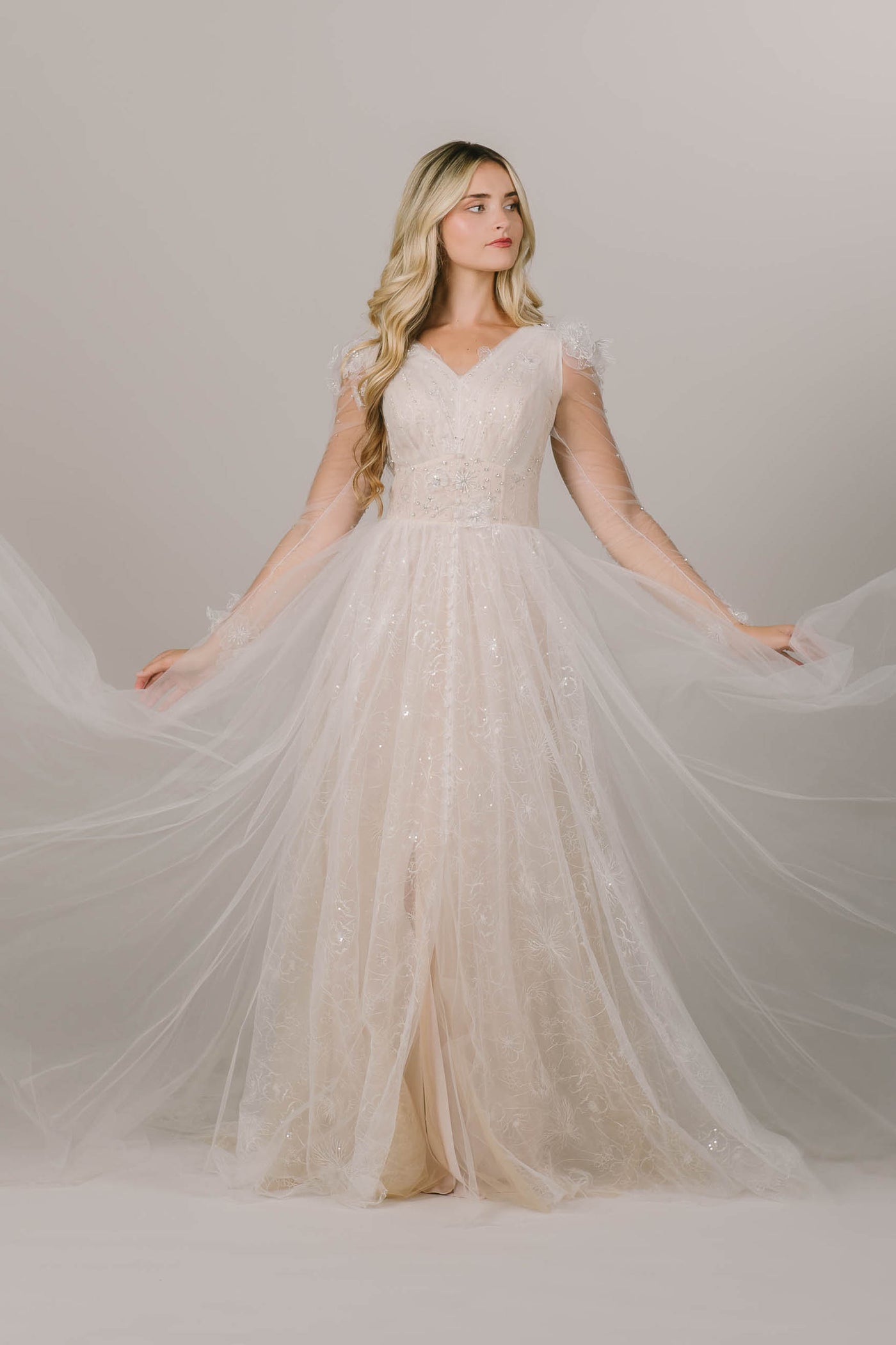 This is a modest wedding dress being shown as flowy and airy.