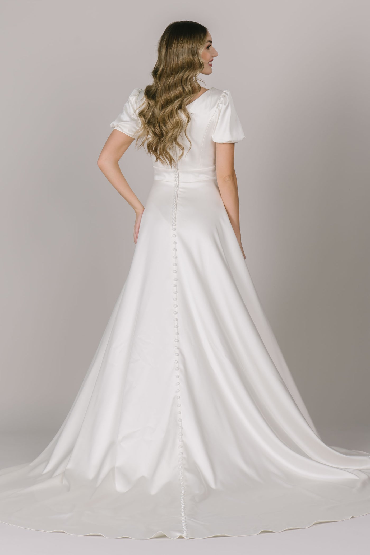 Another back angle of a soft, romantic, and modest wedding dress in Utah with beautiful puff sleeves, pockets, and a beautiful waistline!