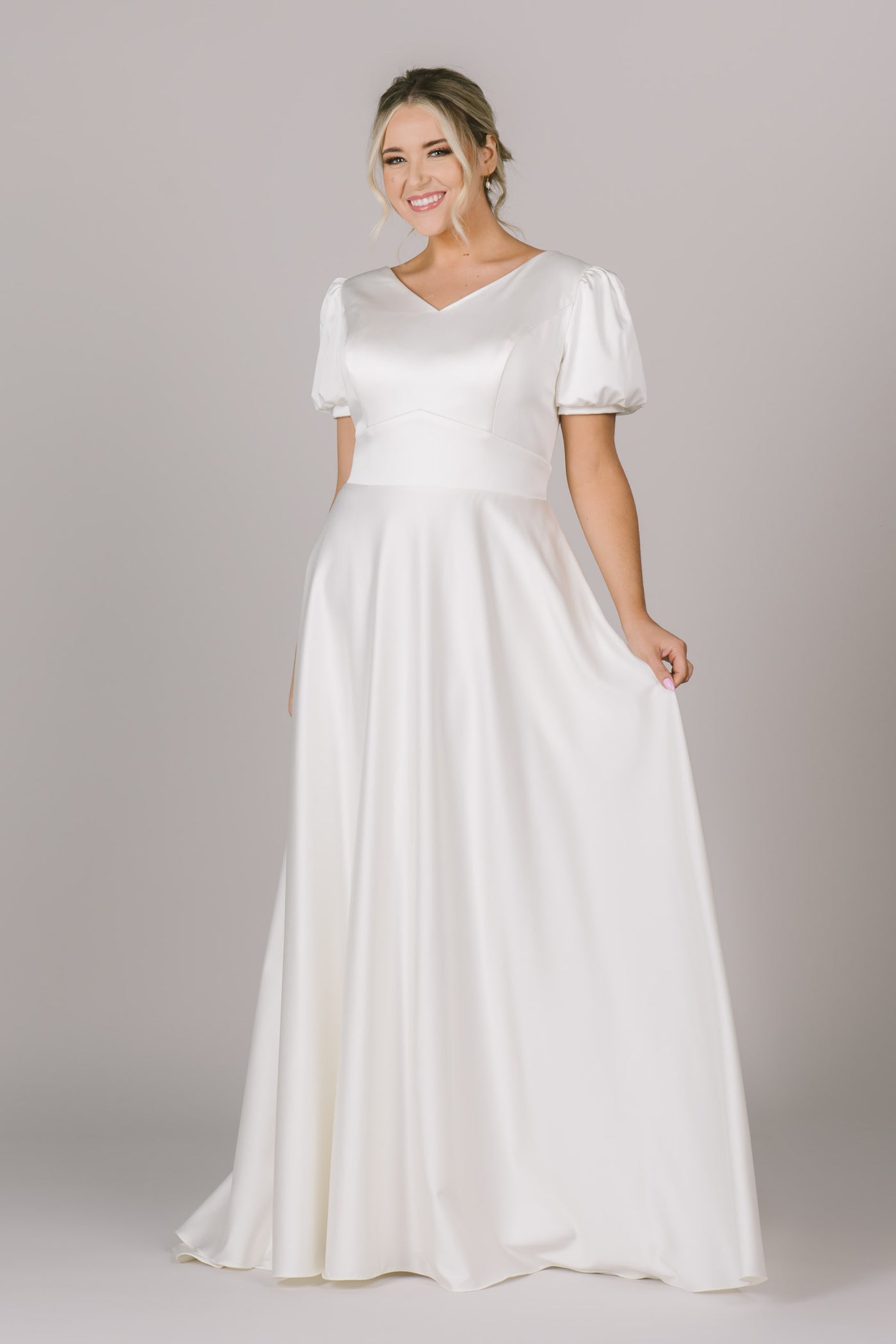 A modest wedding dress in Utah made out of the silkiest and softest material! It features a v-neckline, puff sleeves, and an a-line silhouette, which compliments each body type flawlessly!