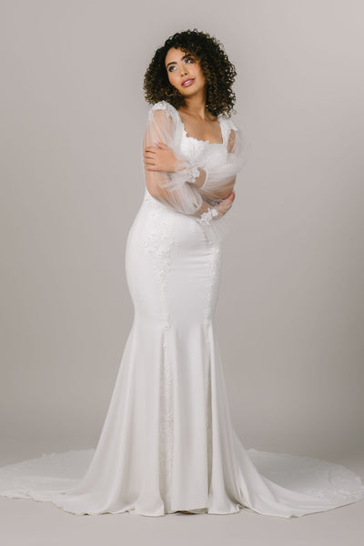 This is an alternate shot of a modest wedding dress with sheer sleeves and lace detailing.