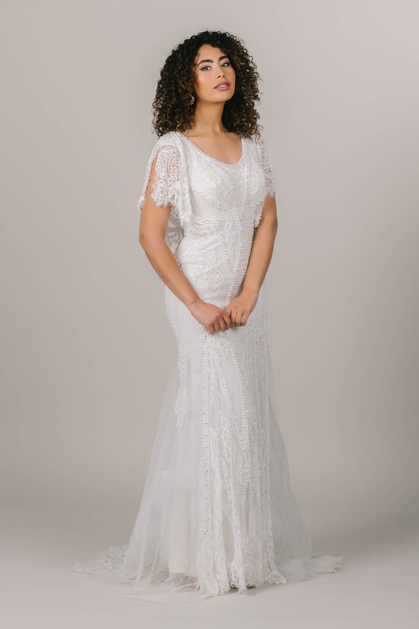 This is an alternate front shot of a modest wedding dress with fun flutter sleeves and intricate beading details
