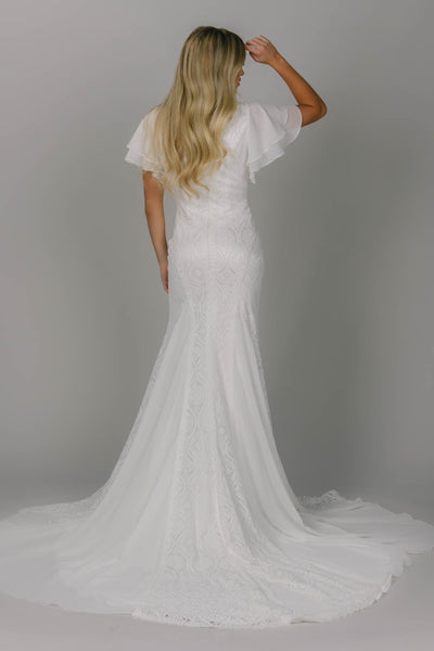 Boho modest wedding dress with sheet lace and chiffon. It has flutter sleeves and it a fitted fit. It has a v-neckline. This modest wedding dress frames the body so beautifully!