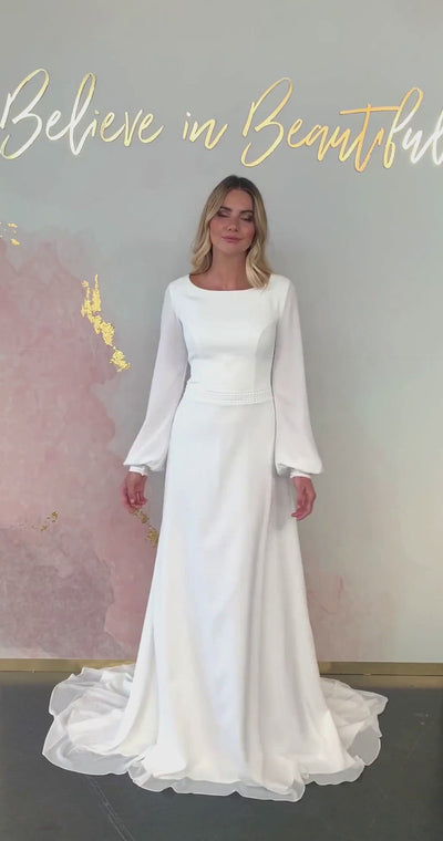 A video featuring our Ella wedding dress and its minimal boho design with chiffon bishop sleeves, and lace cuff detailing.