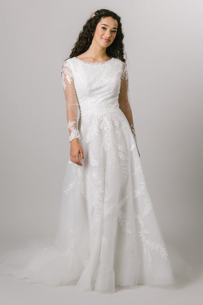 This modest wedding gown features long sleeves with lace throughoutThis modest A-line gown has beading all through the bodice and skirt with flutter sleeves.  the bodice.  