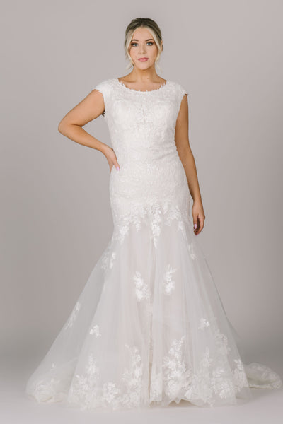 The Capri is a stunning modest wedding dress with a beautiful lace detail that falls throughout the dress.