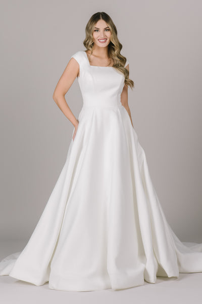 This simple modest wedding dress in Bluffdale, UT has a beautiful square neck, cap sleeves, and ballgown fit make it such an elegant dress!