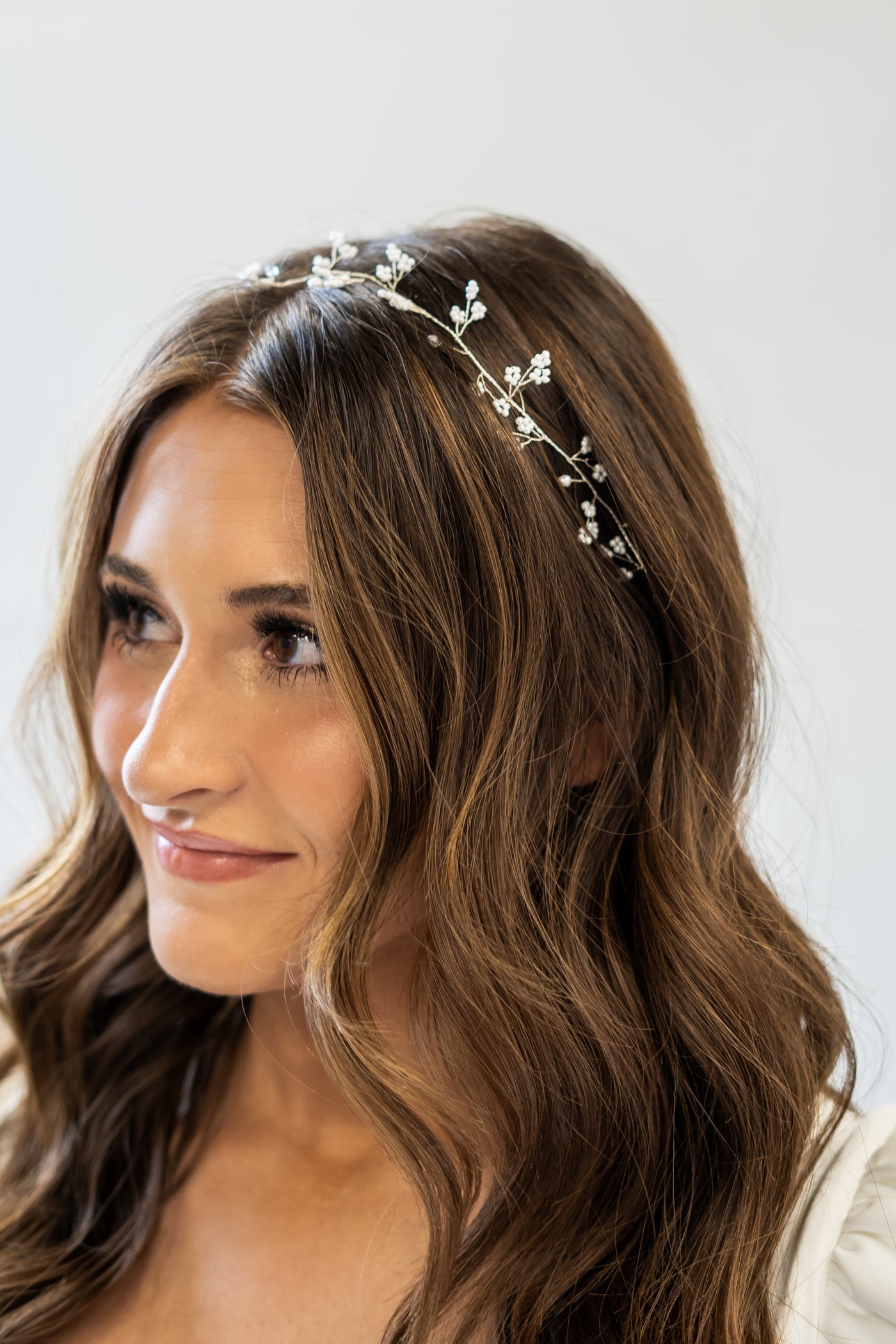 This delicate floral pearl headpiece with a gold band is the perfect accessory for a simple bride.