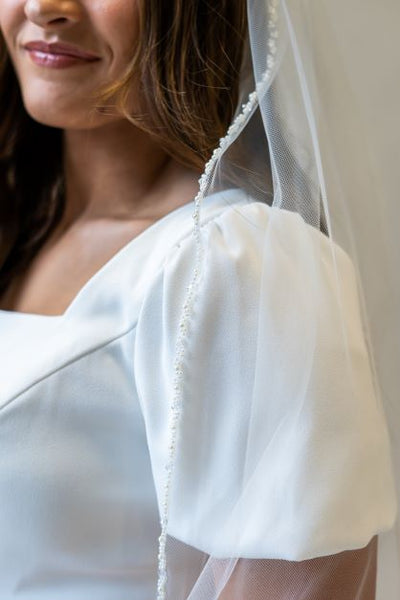 A chapel length veil with dainty pearl edging, perfect to complete your bridal look.