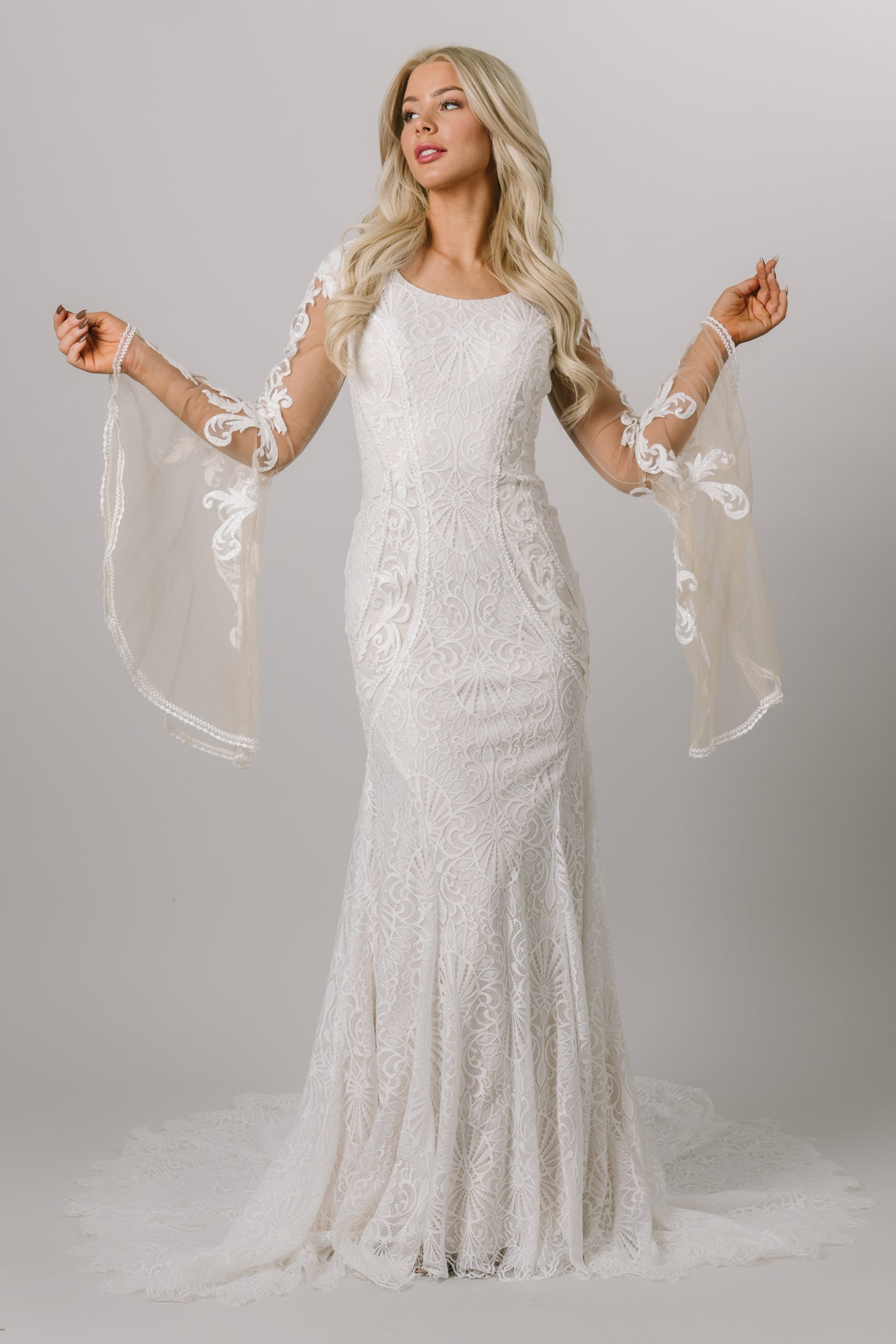 Fitted lace modest wedding dress with bell sleeves. 