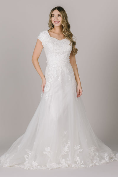 A modest wedding dress in Utah with cap sleeves, intricate lace falling down through the train, and a stunning neckline.