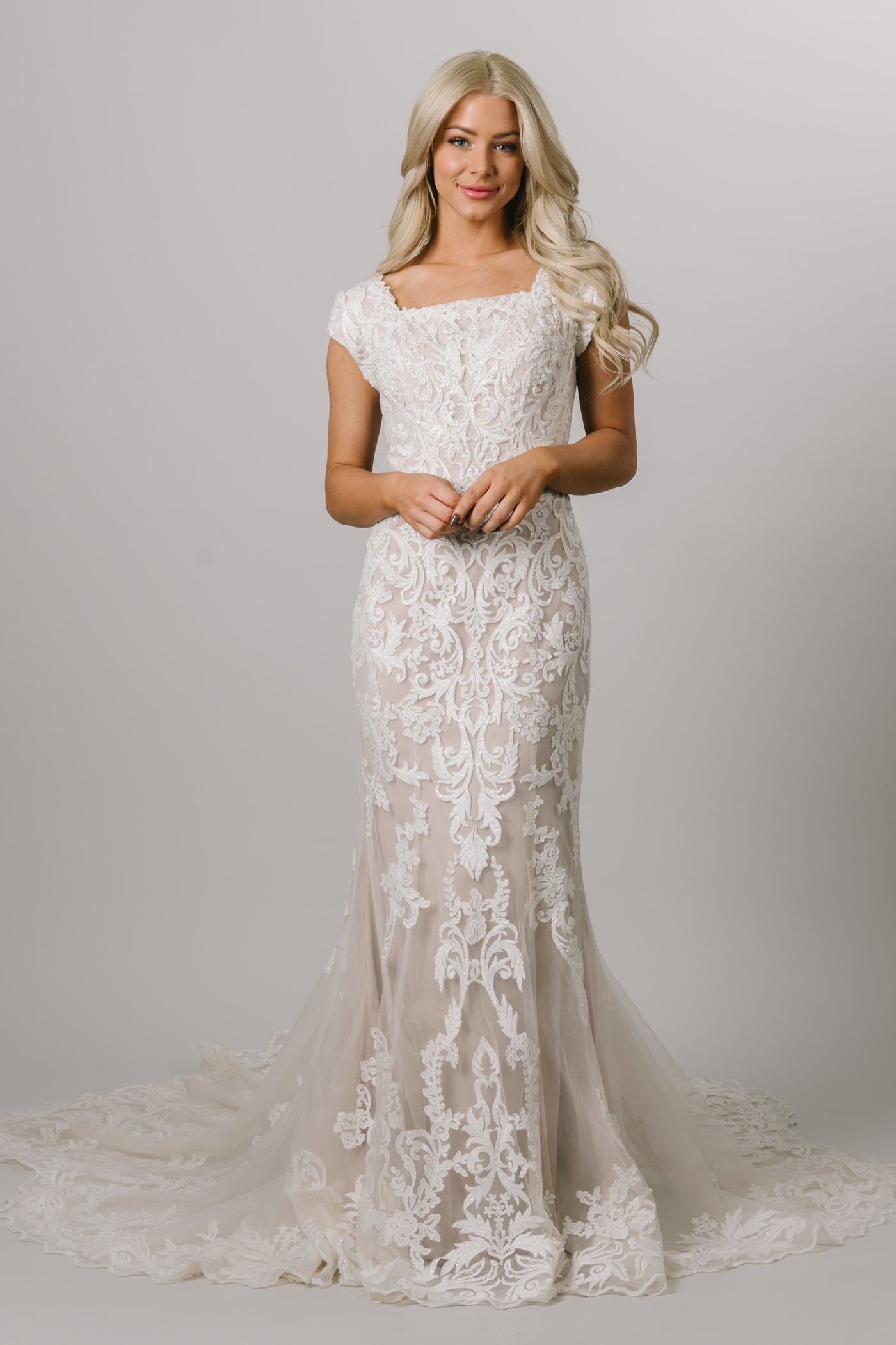 Modest wedding dress with a fitted silhouette square neck, and short sleeves.  