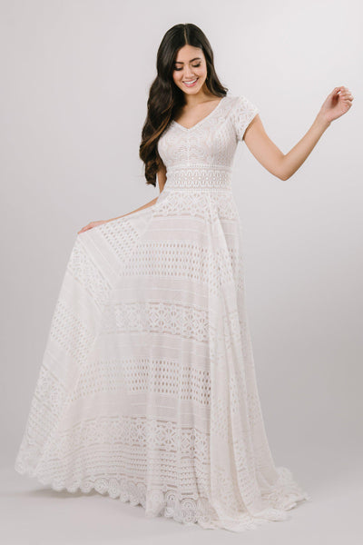 Modest all over lace wedding dress with a soft aline look and cap sleeves at bridal shop in salt lake city utah