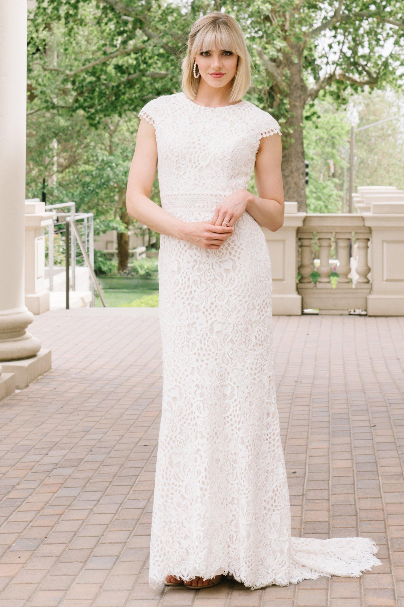 Modest laced wedding dress with capped sleeves featuring a soft aline look from bridal shop in Salt Lake City Utah