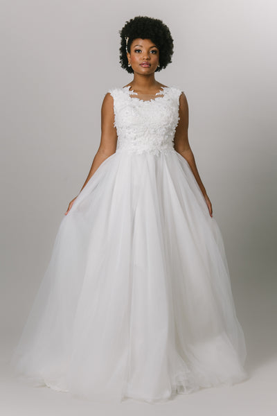 This beautiful ballgown wedding dress features a lace bodice, a tool skirt, cap sleeves, and an illusion lace neckline.