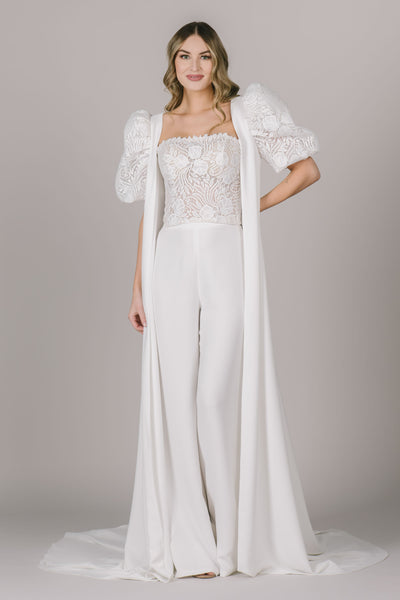 Another picture of this stunning two piece jumpsuit with the added cape. The cape features lace puff sleeves, which make it so easy to switch up the look!