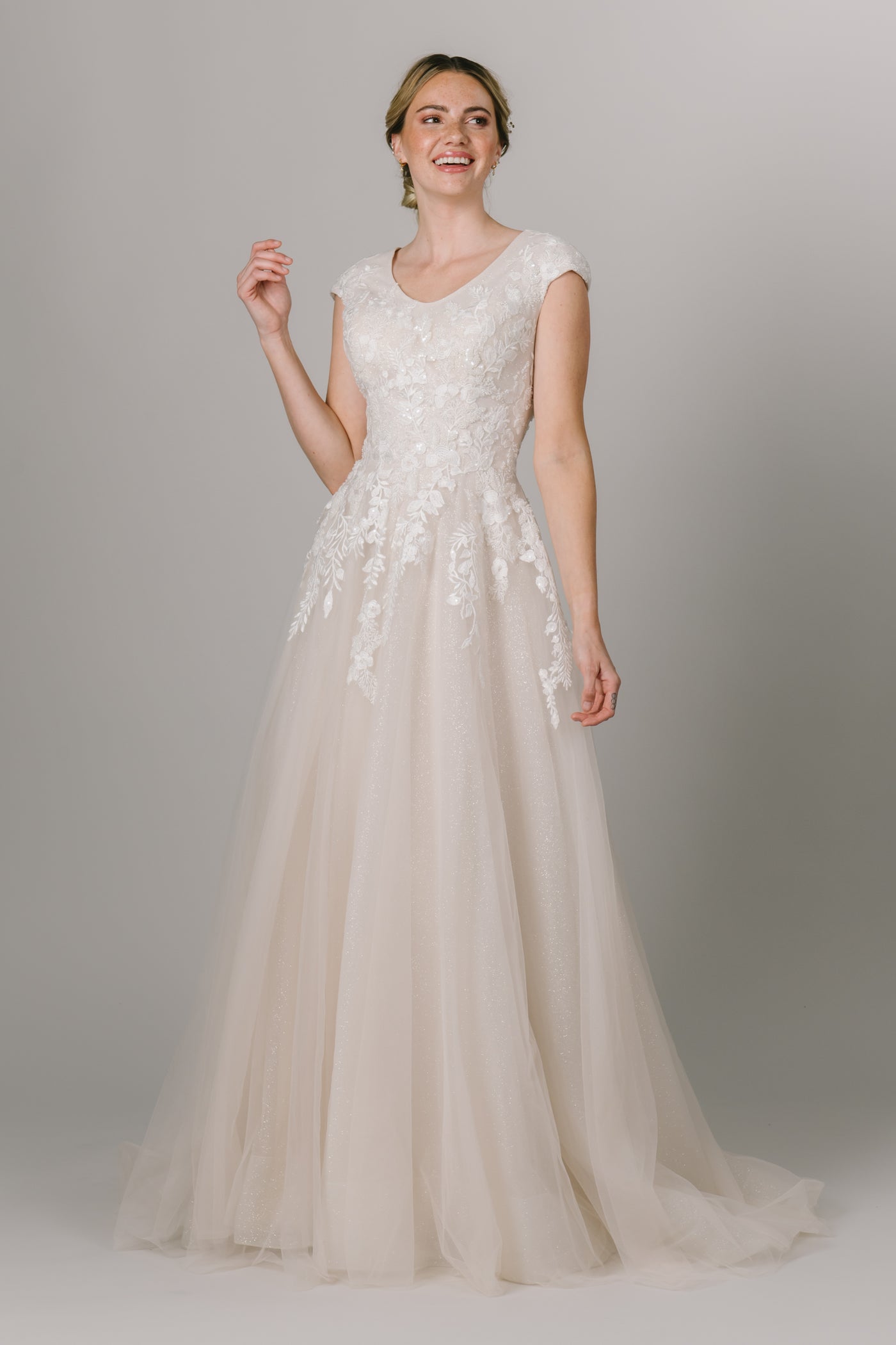 This Modest Wedding Dress features a round neckline, and lace appliques that trickle down the skirt with a glitter lining. - Modest Clothing - Modest Wedding Dresses - Modest Dresses - LatterDayBride