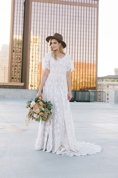 Real bride wearing a boho lace modest wedding dress with flutter sleeves. This modest wedding dress is from LatterDayBride, a bridal shop located in downtown Salt Lake City, Utah.