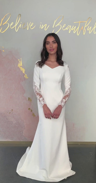 A video featuring our Eliana wedding dress and it's stunning cutout lace sleeves, subtle sit and flare silhouette, and rounded V-neckline.