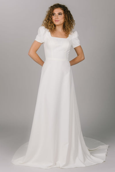 A front shot of this beautiful a-line modest wedding dress with a soft square neckline and puff sleeves.