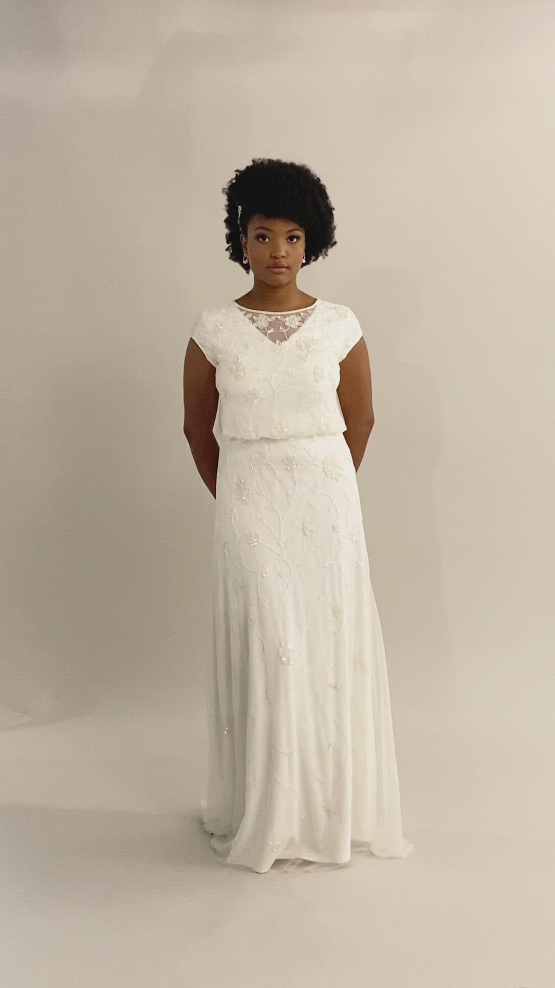 Video of fitted modest wedding dress with cap sleeves. This dress has sheet lace and a fitted fit. It has a v-neckline with a lace scoop neckline overtop.