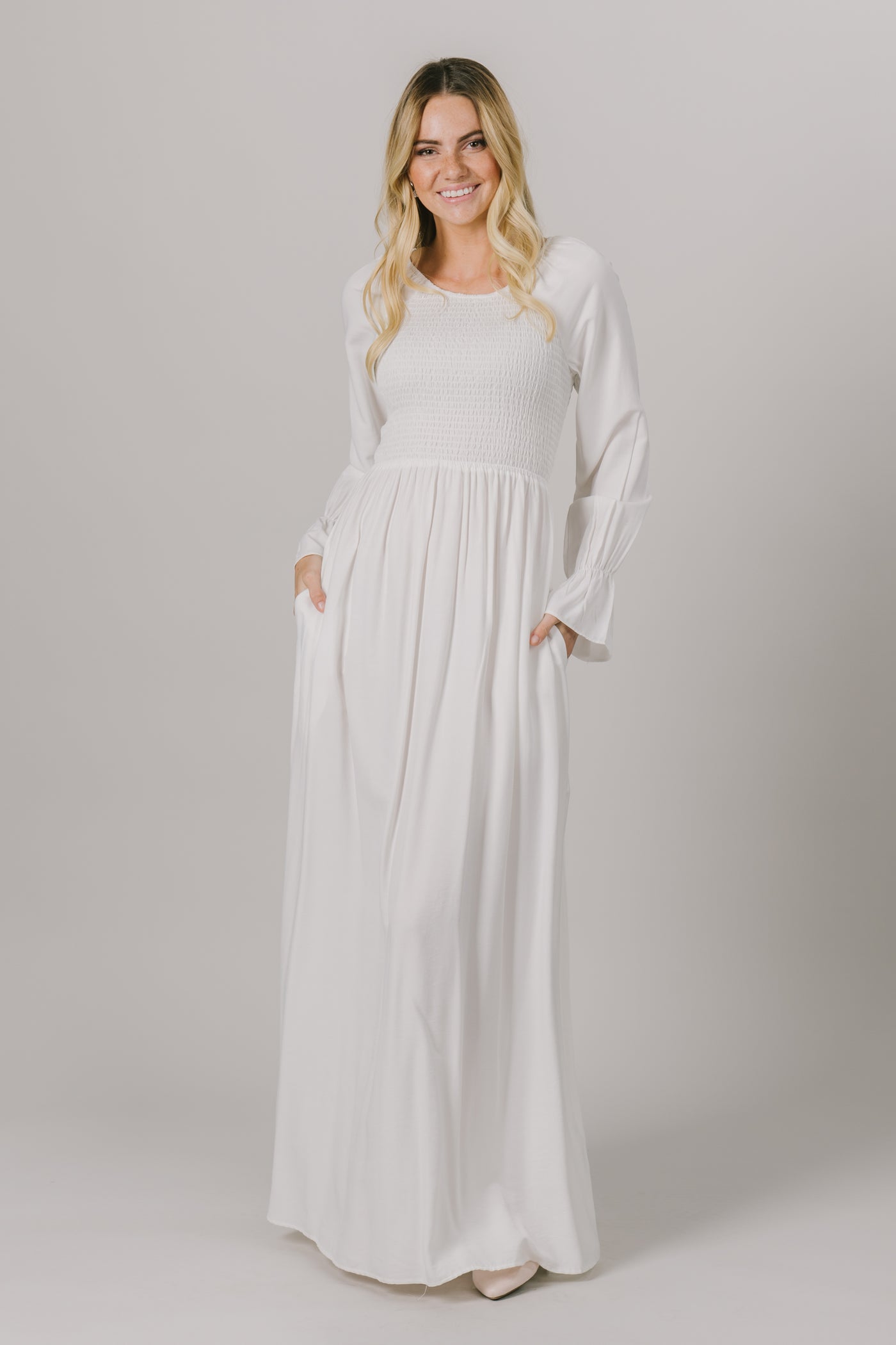 This LDS temple dress features a shirred, textured bodice and fun bell sleeves. It includes two pockets.