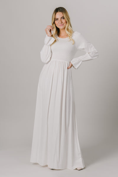 This LDS temple dress features a shirred, textured bodice and fun bell sleeves. It includes two pockets and no zipper close. .
