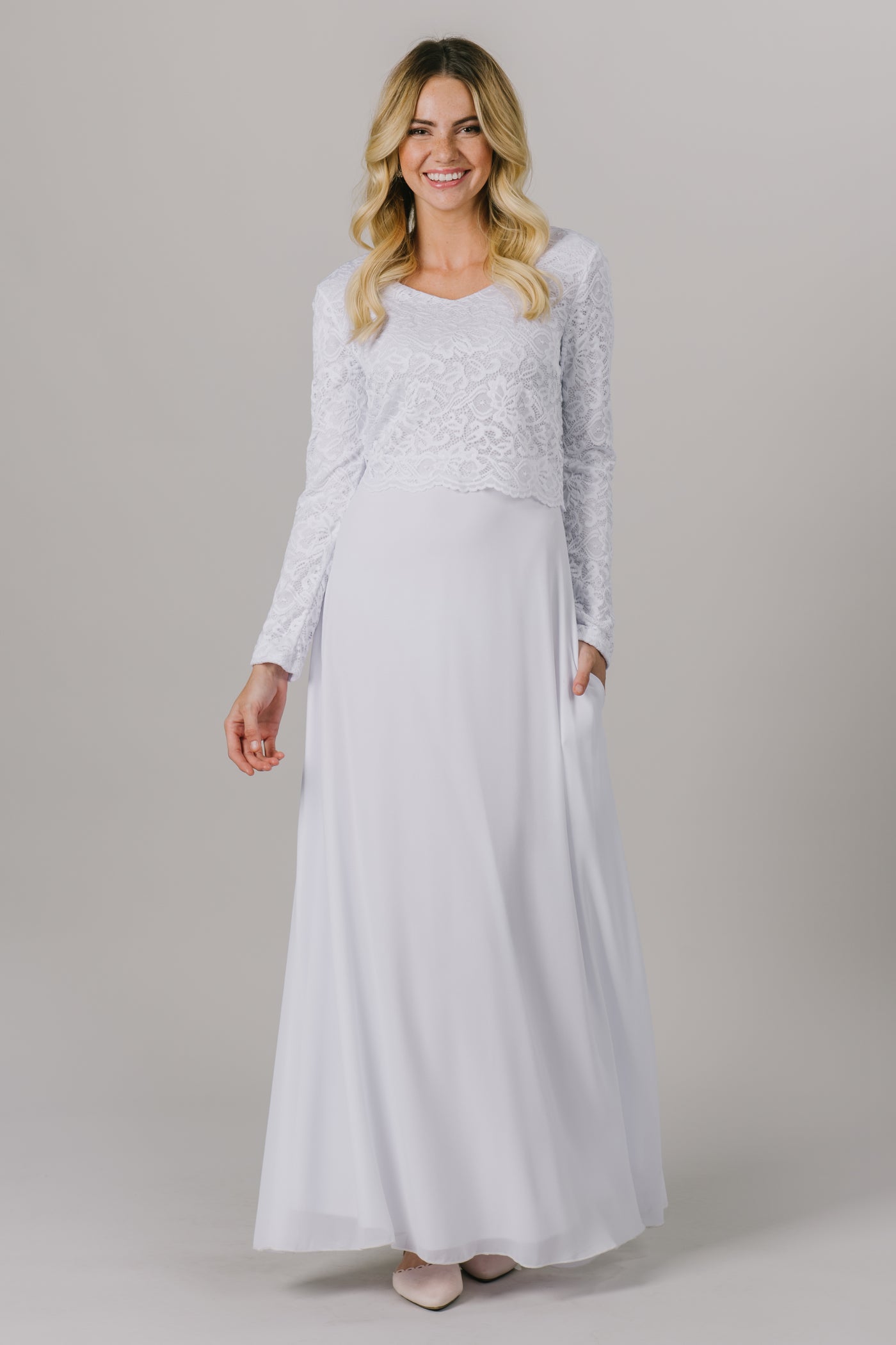 This LDS temple dress features a fully lined, loose lace bodice with a flattering waistband. It includes two pockets and a zipper close.