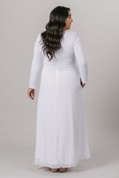 This plus size temple dress features a fully lined, loose lace bodice with a flattering waistband. It includes two pockets and a zipper close. From a bridal shop in downtown Salt Lake City.