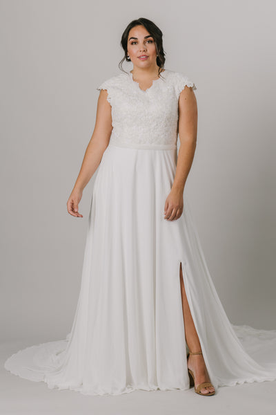 This plus-size wedding dress is an A-line fit featuring a beautiful beaded bodice. Complete with a flattering v-neckline and bead belt, this gown also features a fun slit in the front.