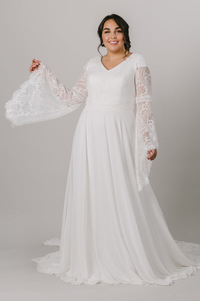 This plus-size modest wedding dress is perfect for our bohemian brides. The A-line silhouette makes it flattering on all figures. The unique lace on the bodice also makes for beautiful, flowy bell sleeves.