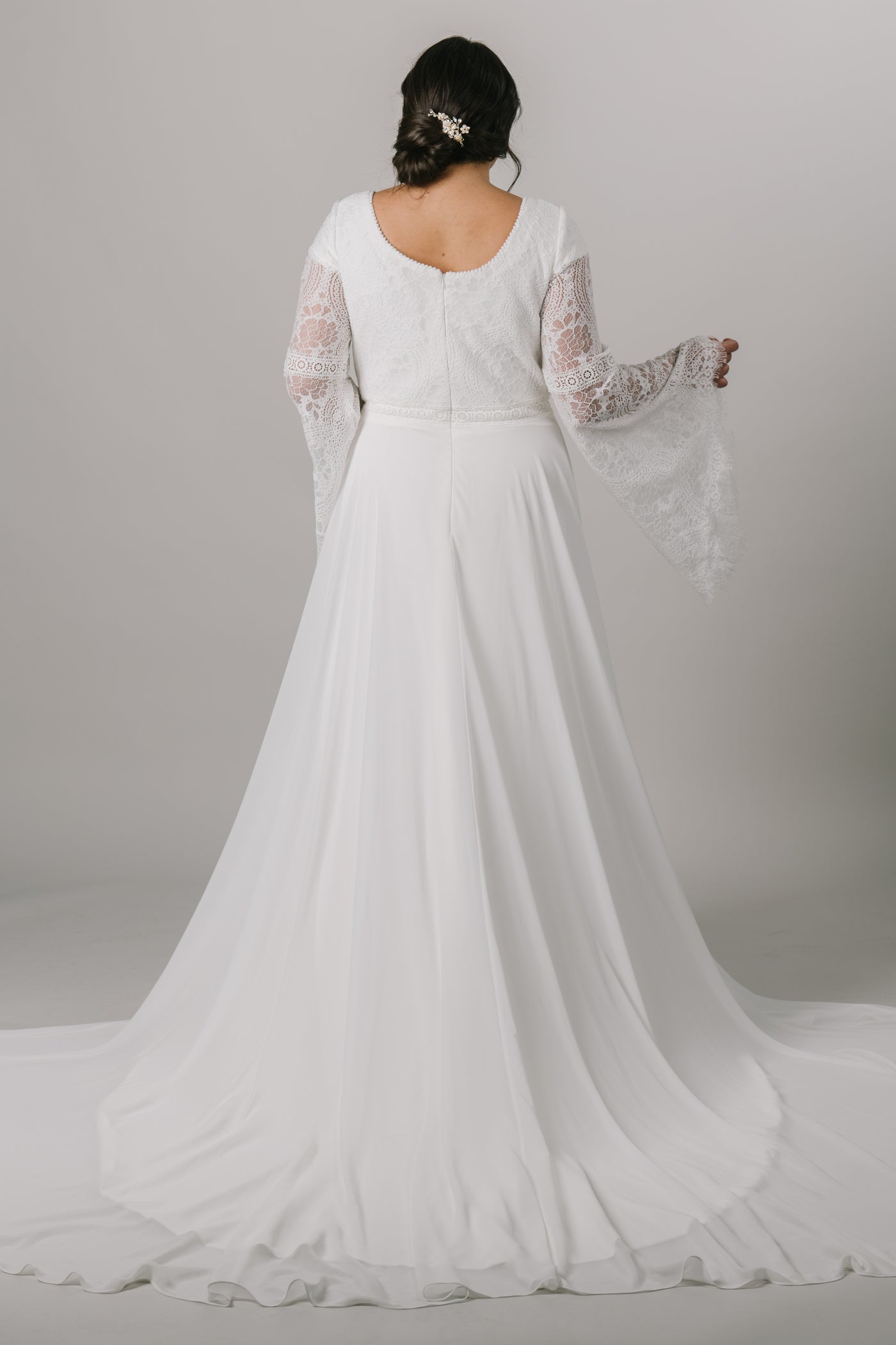 This plus-size modest wedding dress is perfect for our bohemian brides. The A-line silhouette makes it flattering on all figures. The unique lace on the bodice also makes for beautiful, flowy bell sleeves. From a bridal shop in downtown Salt Lake City called LatterDayBride.