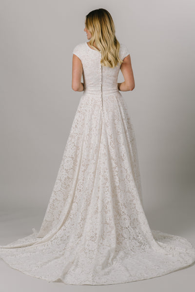 This modest wedding dress has a flattering fit somewhere between an a-line and a ballgown silhouette. It features a dainty full lace pattern and a v-neckline.  Available in Sand/Ivory (pictured) and Almond/Champagne/Ivory. From LatterDayBride in downtown Salt Lake City. 