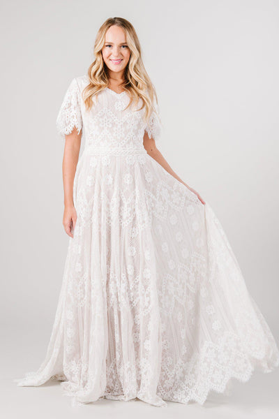 Front view boho lace modest wedding dress with flutter sleeves. This modest wedding dress is from LatterDayBride, a bridal shop located in downtown Salt Lake City, Utah.