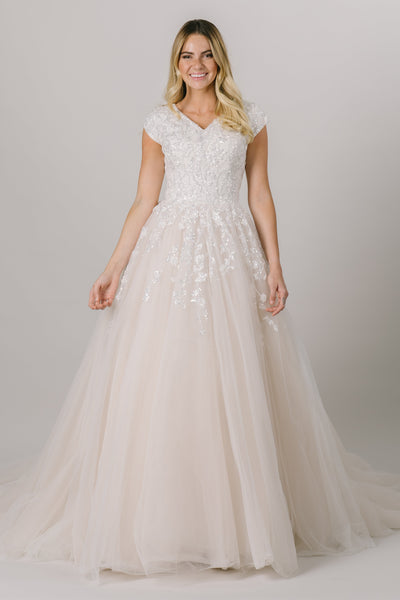 This glamorous modest wedding dress screams princess. From the v neck to the sparkle bodice to the poof in the skirt, this gown is sure to put jaws on the floor.
