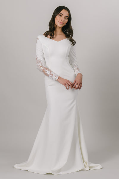 For all of our vivacious and fun brides, this modest wedding dress is for you. This fitted gown features long sleeves and a v-neckline. The otherwise simple dress has a gorgeous lace detail down the sides of the sleeves. 