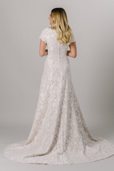 This fitted modest wedding dress is made with a delicate lace pattern and features a fun lace belt. The short illusion sleeves and neckline have the cutest little ruffle. Available in Ivory and Ivory/Cappuccino (as pictured).   ﻿Style Love: This dress is part of our brand new, exclusive LatterDayBride wedding dress collection. From A bridal store located in dowtown SLC,Utah.