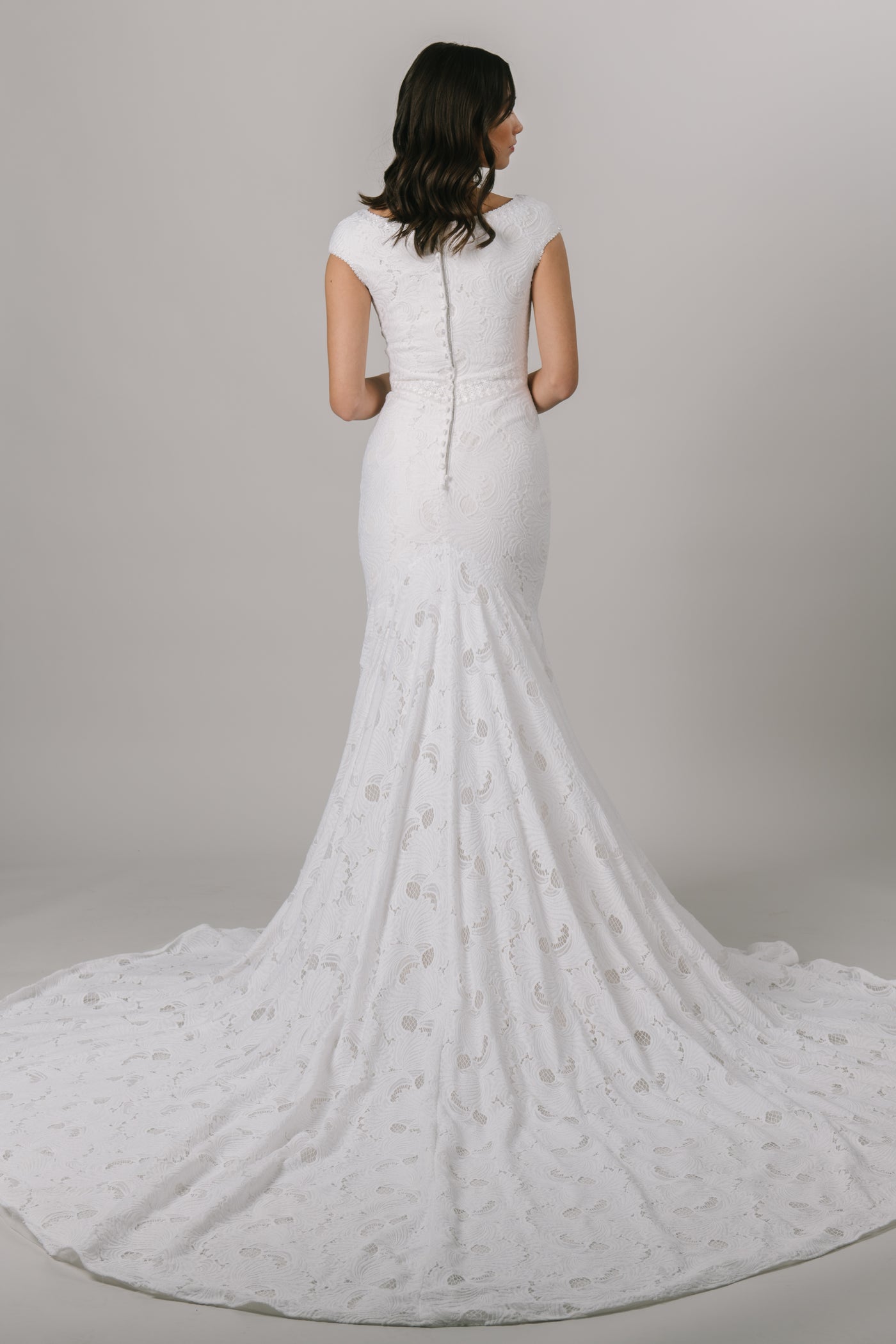 Fall in love with lace all over again! This stunning modest wedding dress features a sophisticated lace pattern, flattering fit-and-flare silhouette and an accentuated waistband that everyone loves!   Shown in Sand/Ivory. From a bridal shop called LatterDayBride in downtown Salt Lake City.