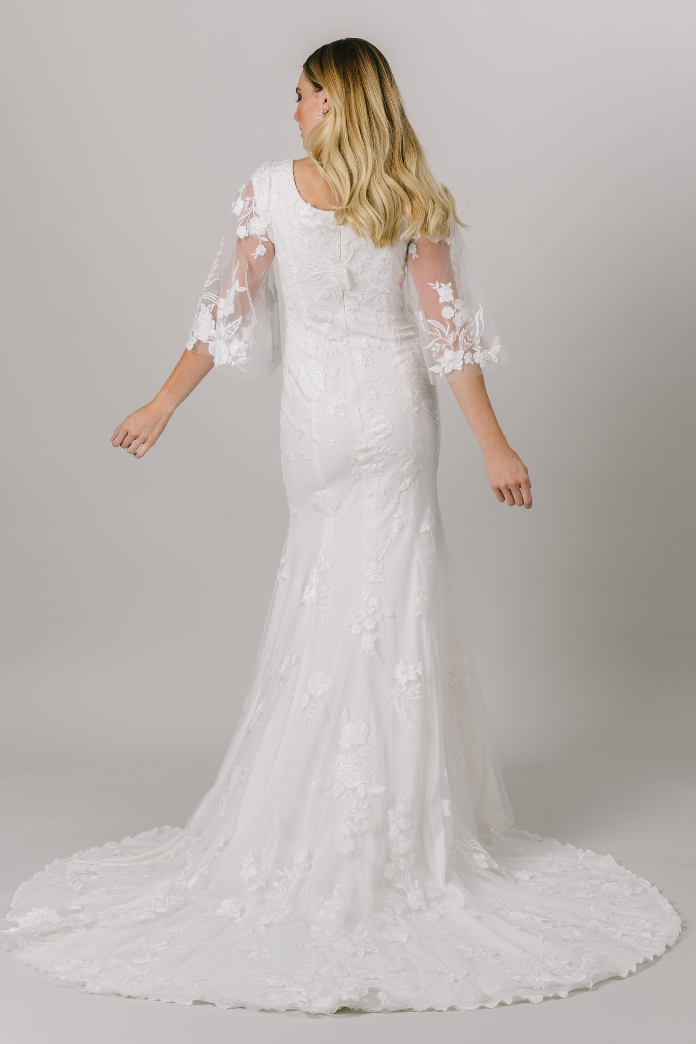 This unique modest wedding gown is like nothing you've seen! It features a v-neckline, fitted silhouette, and gorgeous flowery lace. This gown provides such an amazing fit with details you'll love! Available in Ivory and Ivory/DecoGold. From a bridal shop in downtown Salt Lake City called LatterDayBride.