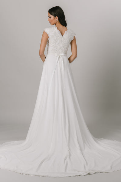 This wedding dress is an A-line fit featuring a beautiful beaded bodice. Complete with a flattering v-neckline and bead belt, this gown also features a fun slit in the front. From a bridal shop called LatterDayBride in downtown Salt Lake City.